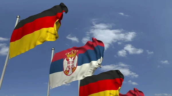 Zwaaiende vlaggen van Servië en Duitsland op Sky achtergrond, 3D rendering — Stockfoto