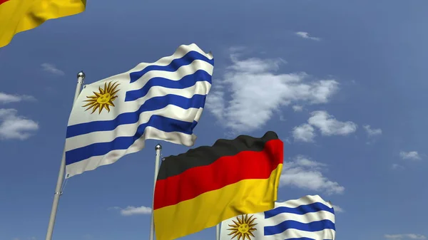 Banderas de Uruguay y Alemania contra el cielo azul, representación 3D — Foto de Stock