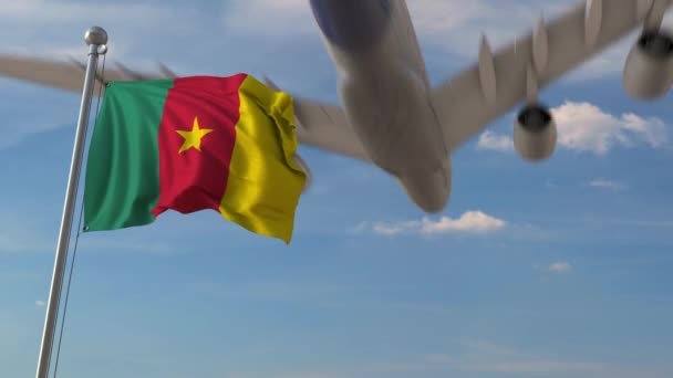 Commercial airplane flying over national flag of Cameroon. Cameroonian air transportation related 3D animation — Stock Video