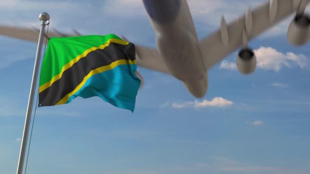 Avião comercial que sobrevoa a bandeira nacional da Tanzânia. Animação 3D relacionada ao transporte aéreo da Tanzânia — Vídeo de Stock