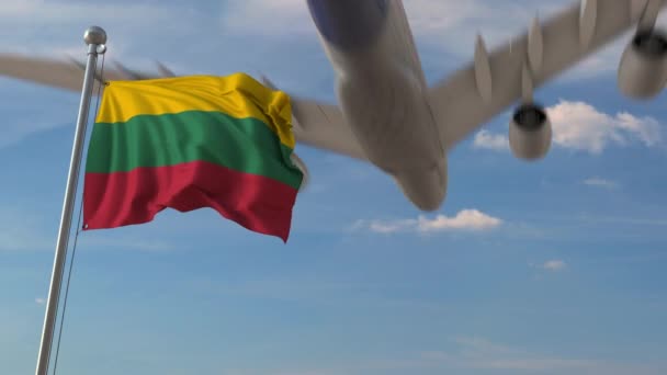 Commercial airplane flying over national flag of Lithuania. Lithuanian air transportation related 3D animation — Stock Video