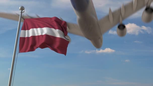 Aereo che passa sopra la bandiera nazionale della Lettonia. Animazione 3D relativa al trasporto aereo lettone — Video Stock