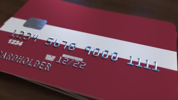Plastic bank card featuring flag of Latvia. Latvian national banking system related animation — Stock Video