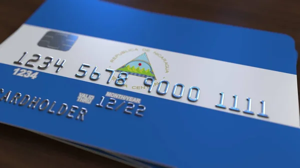Plastic bank card featuring flag of Nicaragua. Nicaraguan national banking system related 3D rendering — Stock Photo, Image