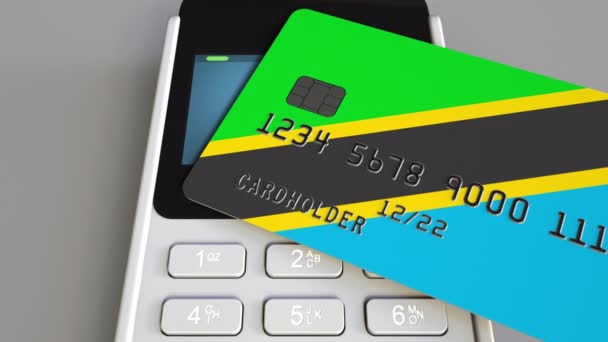 Пластиковая банковская карта с флагом Танзании и платежным терминалом POS. Банковская система Танзании или связанная с розничной торговлей 3D анимация — стоковое видео