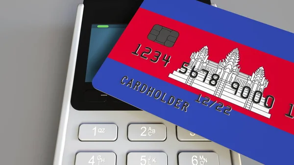 Plastic bank card featuring flag of Cambodia and POS payment terminal. Cambodian banking system or retail related 3D rendering