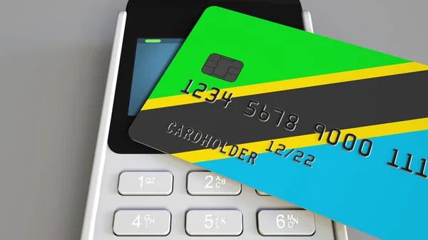 Plastic bank card featuring flag of Tanzania and POS payment terminal. Tanzanian banking system or retail related 3D rendering