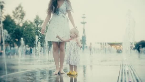 年轻女子和她的小宝宝在城市公园喷泉的乐趣，慢动作 — 图库视频影像