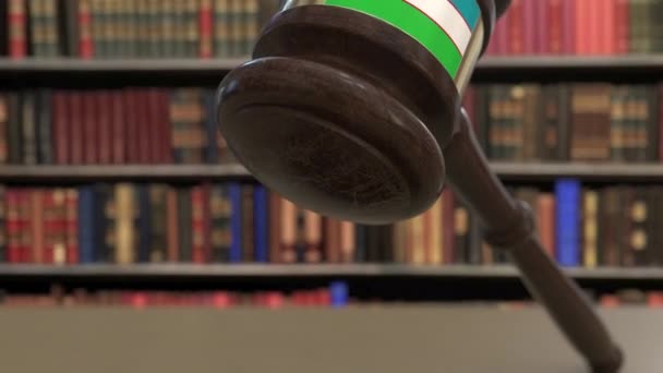 Флаг Узбекистана на падающих судьях молоток в суд. Национальная судебная система или связанная с юрисдикцией концептуальная 3D анимация — стоковое видео
