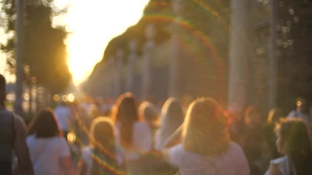 Onbekende jonge mensen lopen langs de straat bij zonsondergang. Slow Motion-opname — Stockvideo
