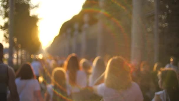 Giovani sconosciuti camminano lungo la strada al tramonto. Colpo al rallentatore — Video Stock