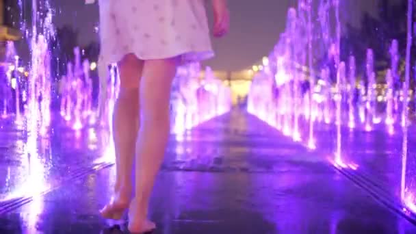 Schlanke junge Frau im Kleid spaziert abends in den Brunnen, Zeitlupenaufnahme — Stockvideo