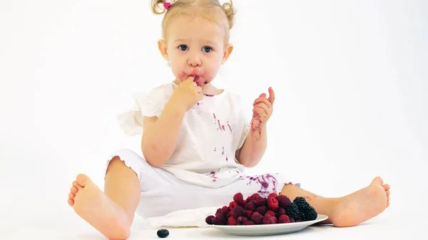 흰색 배경에 신선한 육즙이 많은 열매를 먹는 사랑스러운 아기 소녀 — 스톡 사진