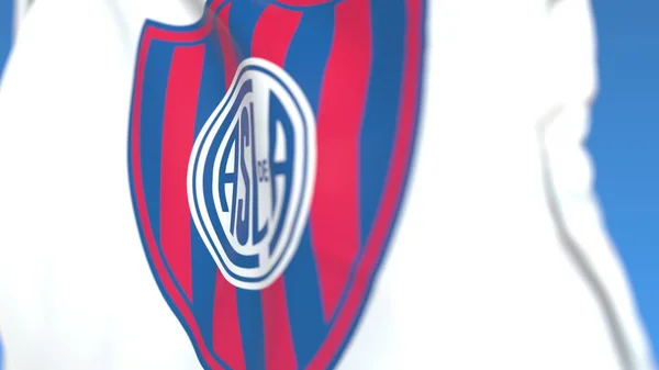 Bandiera sventolante con logo della società calcistica San Lorenzo de Almagro, primo piano. Rendering editoriale 3D — Foto Stock