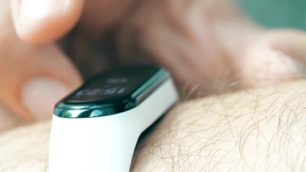 Mężczyzna używa inteligentnej bransoletki lub fitness tracker na nadgarstku, zbliżenie strzał — Wideo stockowe