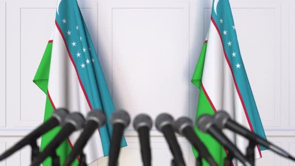 Uzbek official press conference. Flags of Uzbekistan and microphones. Conceptual 3D animation — Stock Video