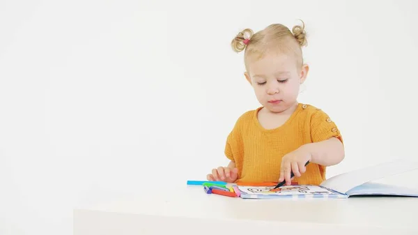 Blonďatý dětský barevný obraz s pastelkou na bílém pozadí — Stock fotografie