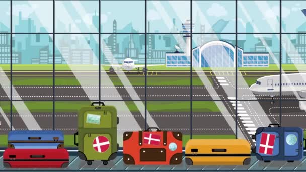 Bagaż z duńskimi naklejkami z flagą na karuzeli bagażowej na lotnisku. Turystyka w Danii konceptualna animacja kreskówek — Wideo stockowe