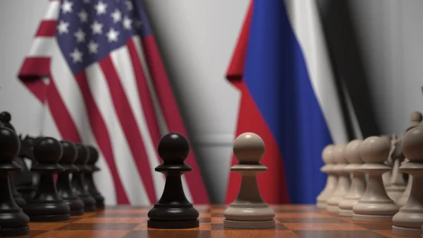 Drapeaux des États-Unis et de la Russie derrière l'échiquier. Le premier pion se déplace au début du jeu. Rivalité politique rendu 3D conceptuel — Photo