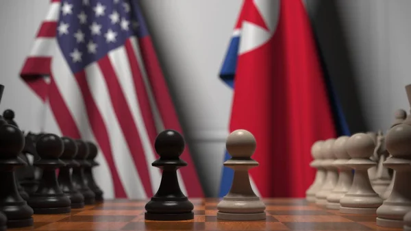 チェスボードの後ろにアメリカと北朝鮮の旗。最初のポーンは、ゲームの開始時に移動します。政治的ライバル概念3Dレンダリング — ストック写真