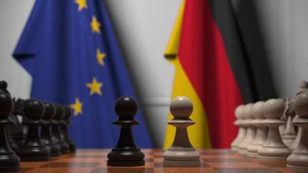 Drapeaux de l'UE et de l'Allemagne derrière l'échiquier. Le premier pion se déplace au début du jeu. Rivalité politique rendu 3D conceptuel — Photo