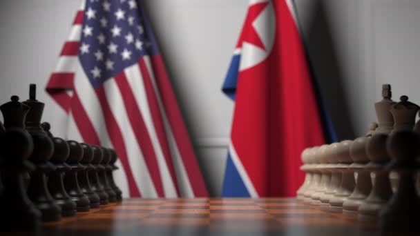 Flaggen der USA und Nordkoreas hinter dem Schachbrett. Der erste Bauer zieht zu Beginn der Partie. politische Rivalität konzeptionelle 3D-Animation — Stockvideo