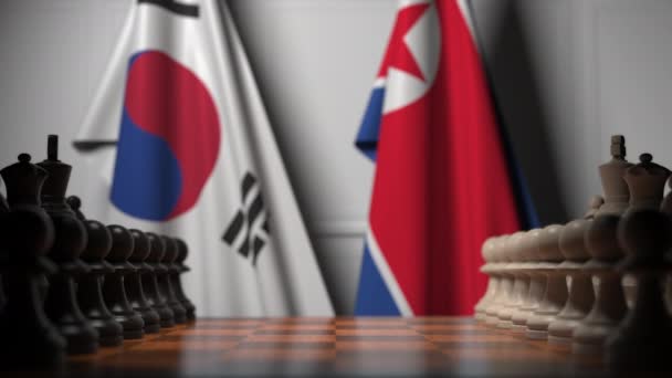 Флаги Южной Кореи и Северной Кореи за шахматной доской. Первая пешка движется в начале игры. Концептуальная 3D анимация — стоковое видео