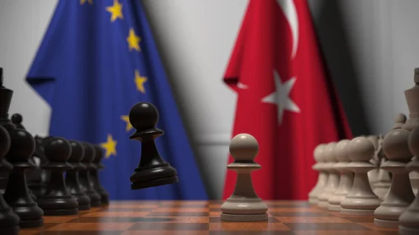 Drapeaux de l'UE et de la Turquie derrière l'échiquier. Le premier pion se déplace au début du jeu. Rivalité politique rendu 3D conceptuel — Photo