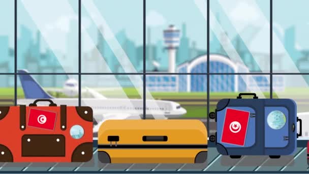 Bagage met Tunesische vlag stickers op Bagage carrousel in luchthaven, close-up. Toerisme in Tunesië gerelateerde loop bare cartoon animatie — Stockvideo