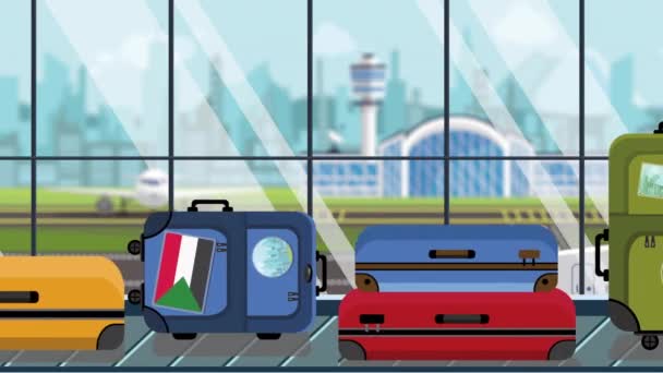 空港の手荷物カルーセルにスーダンの旗のステッカーが貼ったスーツケース、クローズアップ。スーダン関連のループ可能な漫画のアニメーションへの旅行 — ストック動画