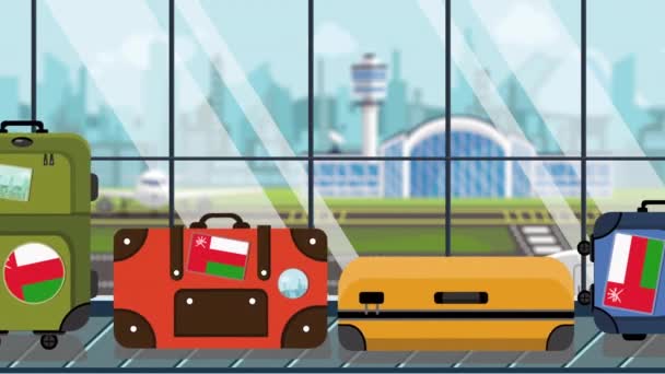 Maletas con pegatinas de bandera de Omán en el carrusel de equipaje en el aeropuerto, primer plano. Animación de dibujos animados loopable relacionada con el turismo omaní — Vídeo de stock