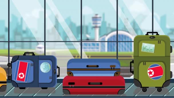 空港の手荷物カルーセルに北朝鮮国旗のステッカーが貼ったスーツケース、クローズアップ。観光関連のループ可能な漫画のアニメーション — ストック動画
