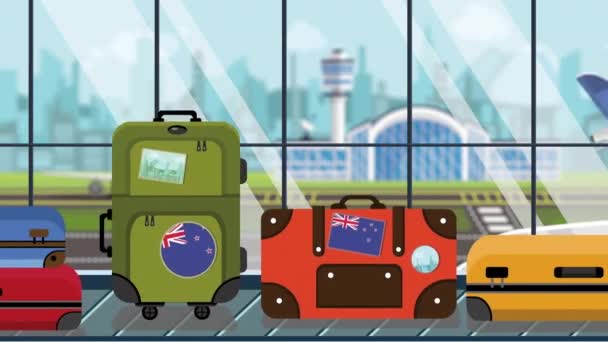 Maletas con pegatinas de bandera de Nueva Zelanda en el carrusel de equipaje en el aeropuerto, de cerca. Animación de dibujos animados loopable relacionados con el turismo — Vídeo de stock