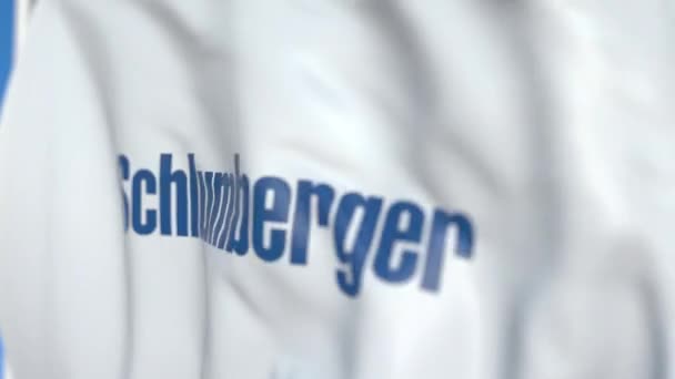 Latająca flaga z logo Schlumberger, zbliżenie. Redakcyjnej pętli animacji 3D — Wideo stockowe
