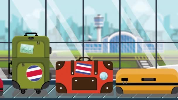 Bagages avec autocollants drapeau du Costa Rica sur le carrousel de bagages à l'aéroport, gros plan. Tourisme lié animation de bande dessinée bouclable — Video