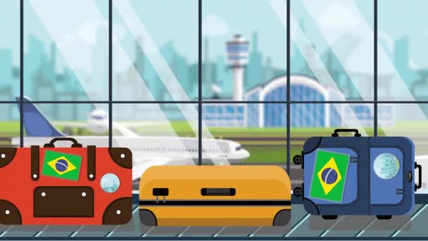 Bagage met Brazilië vlag stickers op Bagage carrousel in luchthaven, close-up. Braziliaanse toerisme gerelateerde loop bare cartoon animatie — Stockvideo