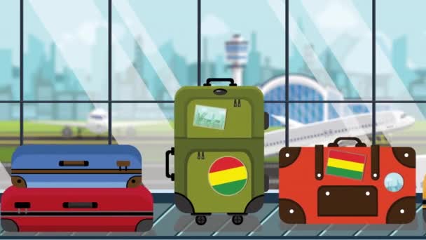 Bagage met Boliviaanse vlag stickers op carrousel in luchthaven, close-up. Toerisme in Bolivia gerelateerde loop bare cartoon animatie — Stockvideo