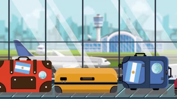 공항의 수하물 회전 목마에 아르헨티나 국기 스티커가 붙은 가방, 클로즈업. 아르헨티나 여행 관련 반복 가능한 만화 애니메이션 — 비디오
