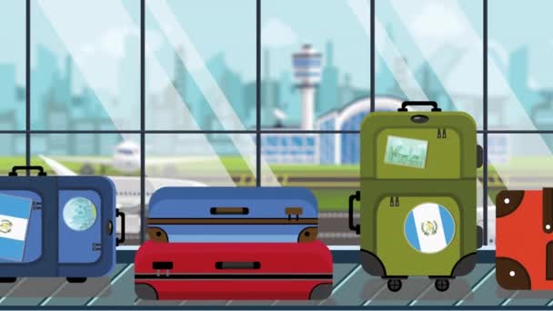 空港の手荷物カルーセルにグアテマラの旗のステッカーが貼ったスーツケース、クローズアップ。グアテマラの観光関連ループ可能な漫画のアニメーション — ストック動画