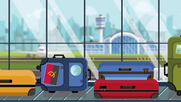 空港の手荷物カルーセルにアンゴラの旗のステッカーが貼ったスーツケース、クローズアップ。アンゴラ関連のループ可能な漫画のアニメーションへの旅行 — ストック動画