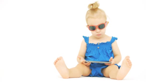 Ernstige baby dragen zonnebril horloges film of cartoon op een moderne smartphone — Stockvideo