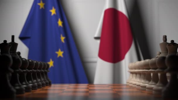 Flaggen der EU und Japans hinter dem Schachbrett. Der erste Bauer zieht zu Beginn der Partie. politische Rivalität konzeptionelle 3D-Animation — Stockvideo