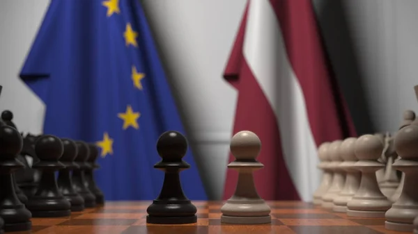 Bandiere dell'UE e della Lettonia dietro la scacchiera. Il primo pedone si muove all'inizio del gioco. Rivalità politica rendering concettuale 3D — Foto Stock