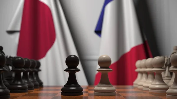 Σημαίες της Ιαπωνίας και της Γαλλίας πίσω από την σκακιέρα. Το πρώτο πιόνι κινείται στην αρχή του παιχνιδιού. Πολιτική αντιπαλότητα εννοιολογική απόδοση 3D — Φωτογραφία Αρχείου