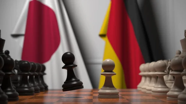 Vlaggen van Japan en Duitsland achter schaakbord. De eerste pion beweegt in het begin van het spel. Politieke rivaliteit conceptuele 3D-rendering — Stockfoto