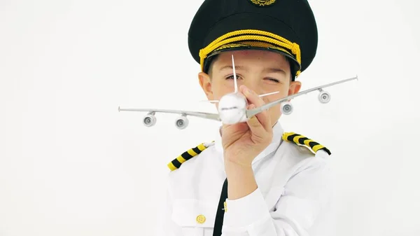 Menino vestindo pilotos uniformes joga com avião de brinquedo — Fotografia de Stock