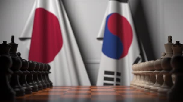 Schaakspel tegen vlaggen van Japan en Zuid-Korea. Politieke competitie gerelateerde 3D-animatie — Stockvideo