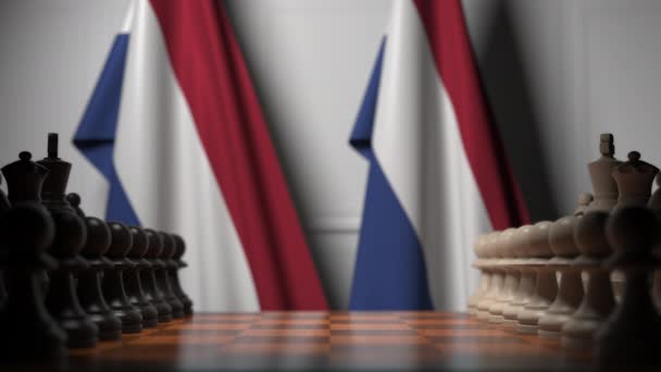 Schaakspel tegen vlaggen van Nederland. Politieke competitie gerelateerde 3D-animatie — Stockvideo