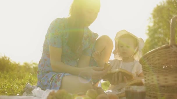 Piccola bambina e sua madre che fanno un picnic insieme in una giornata estiva soleggiata — Video Stock