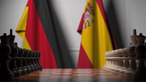 Шахматная игра против флагов Германии и Испании. Политическая конкуренция — стоковое видео